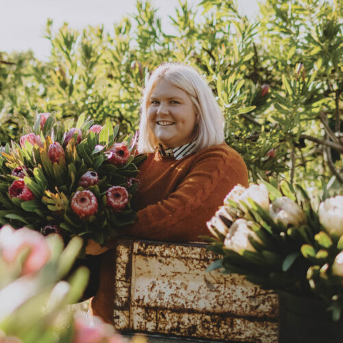 Nikki Davey surround by fresh native flowers.