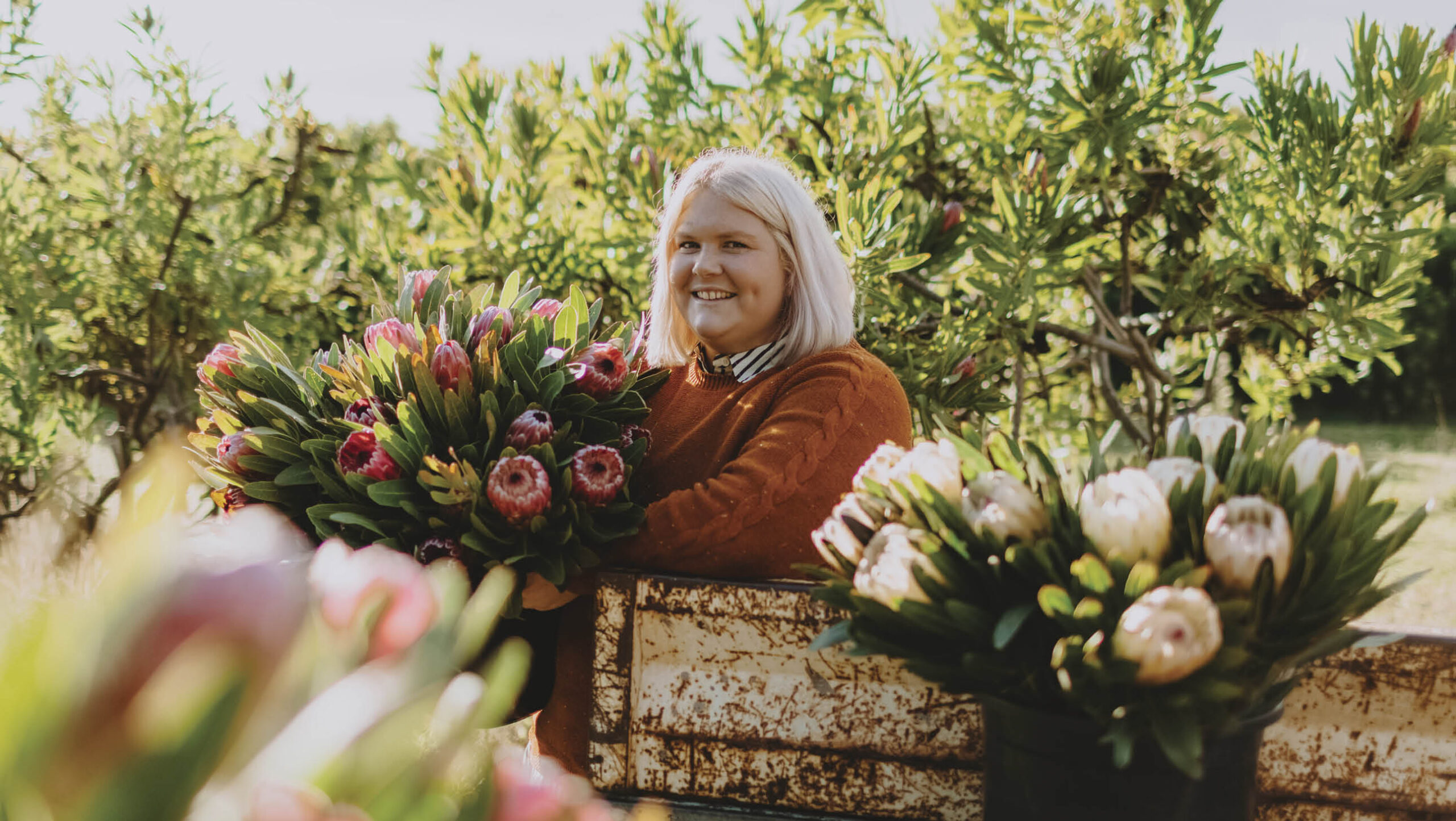 Nikki Davey surround by fresh native flowers.