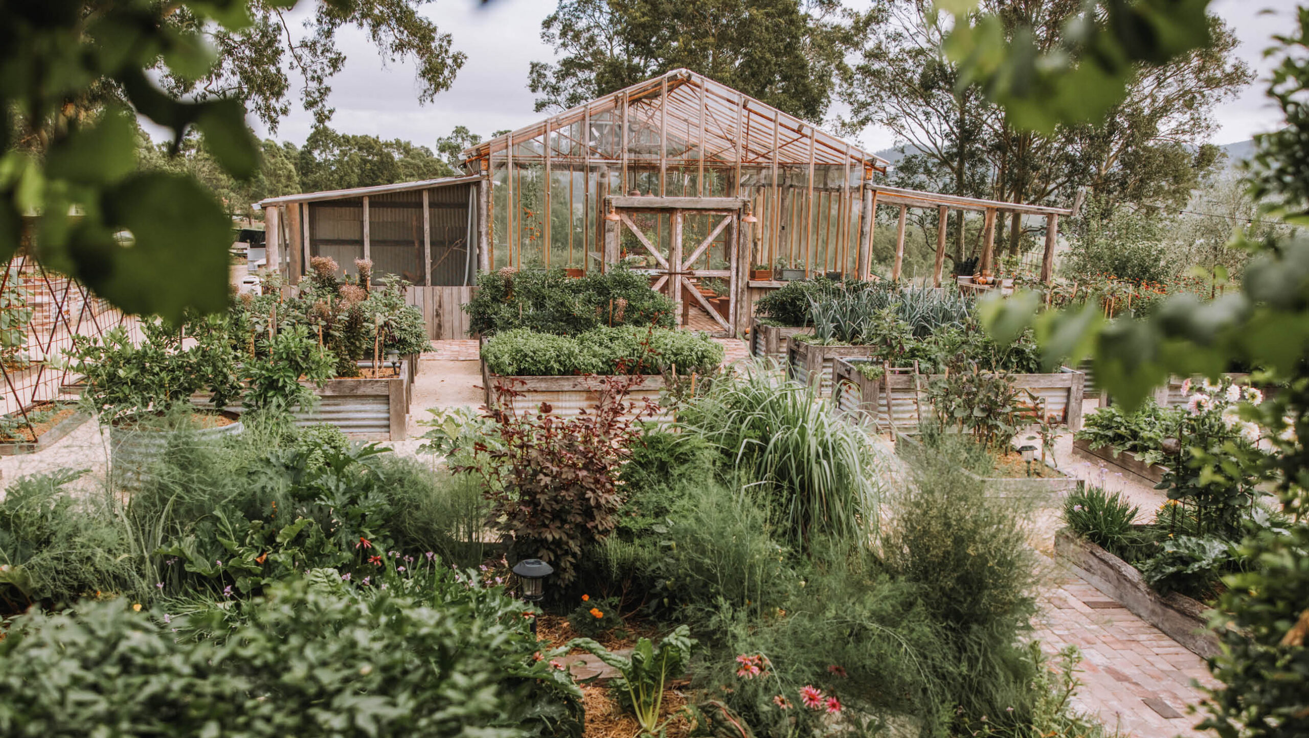 Glasshouse surrounded by a kitchen garden.