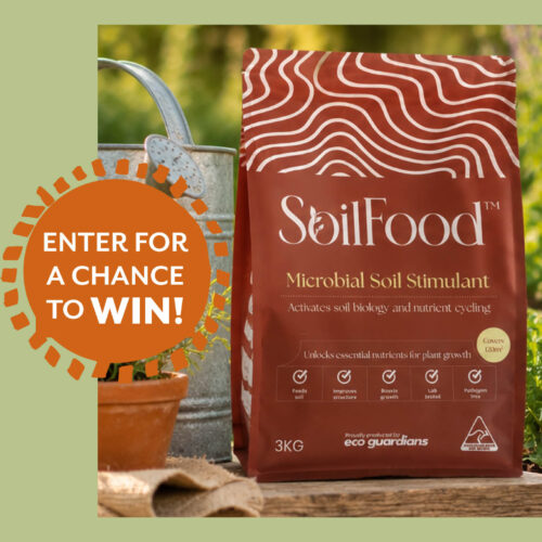 Bag of SoilFood soil additive in a garden.