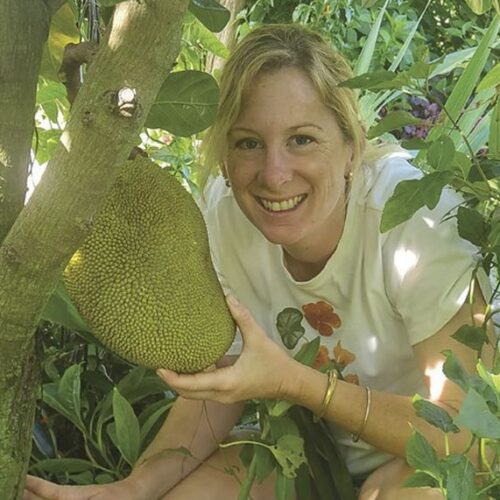 Kat Pearson holding a jackfruit growing in her Brisbane garden