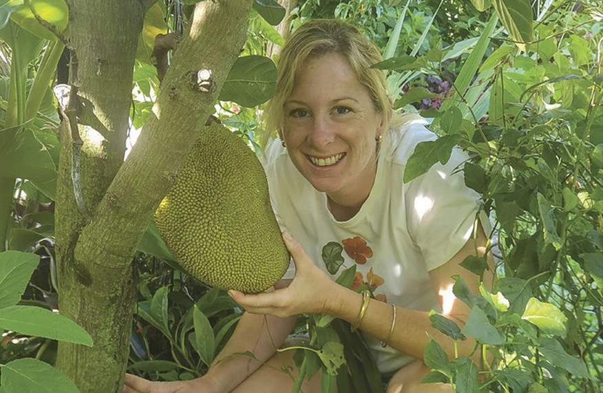 Kat Pearson holding a jackfruit growing in her Brisbane garden